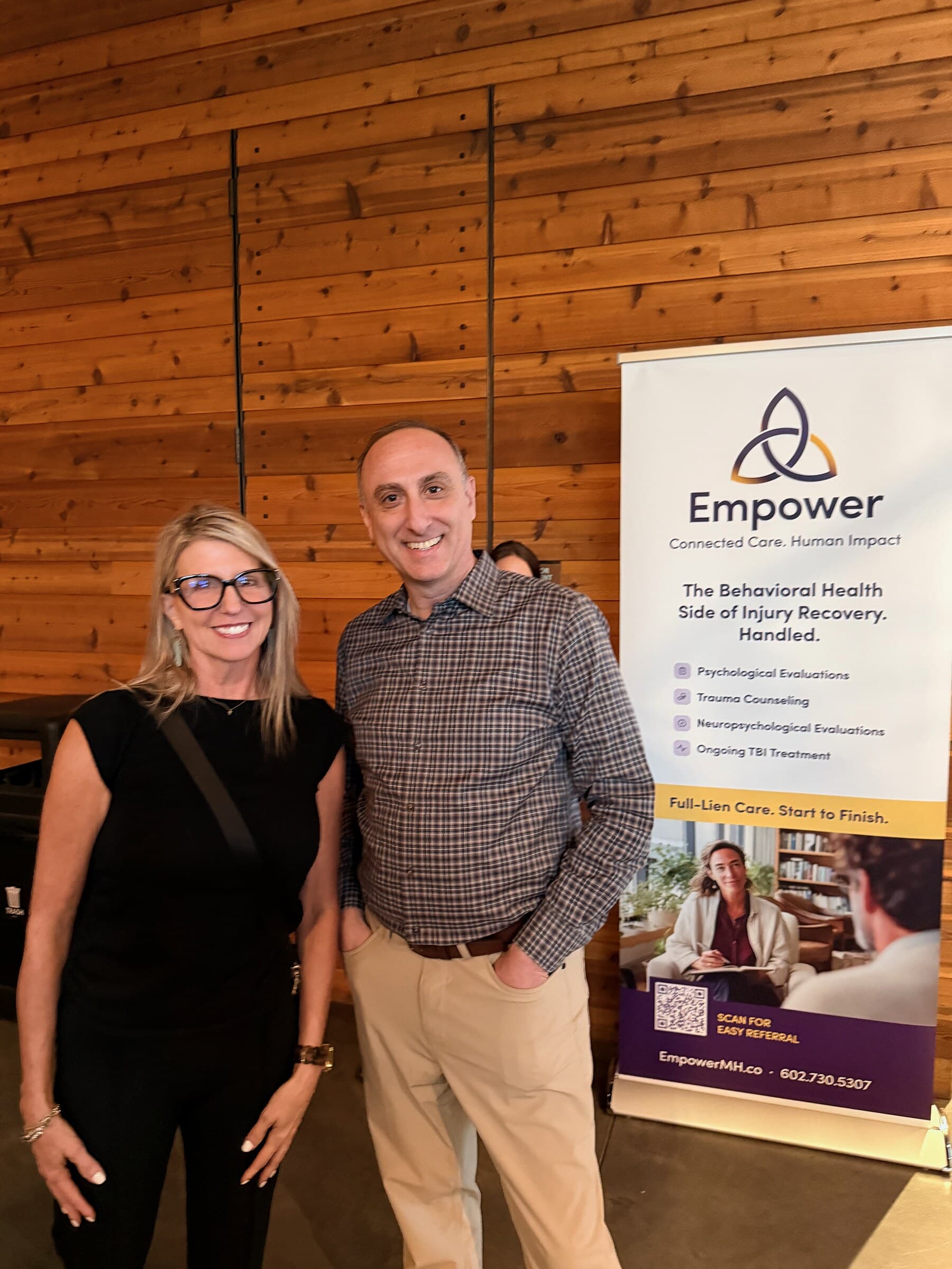 Two attendees standing beside an Empower banner at the KTAR News town hall