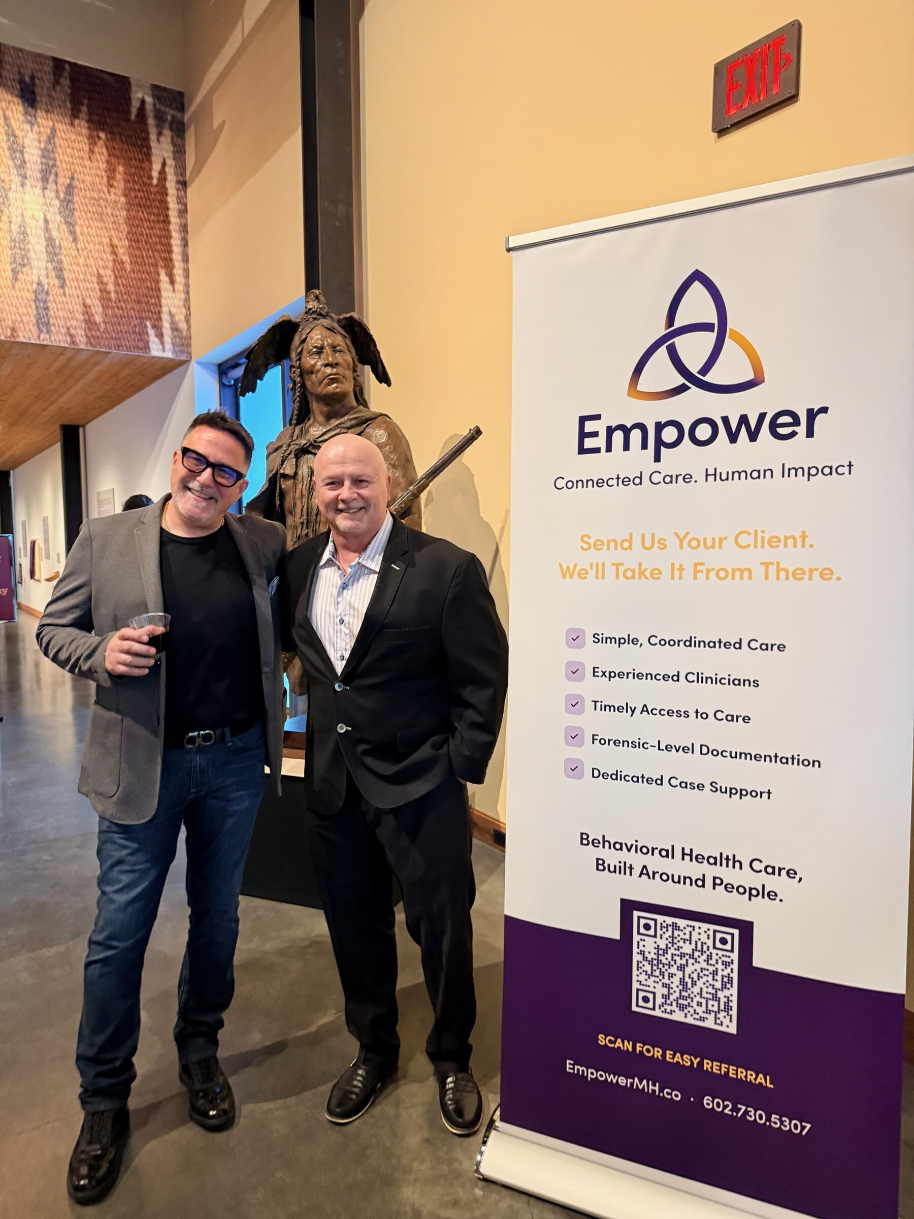 Empower Chief Growth Officer Anthony Conti with Mike Broomhead beside an Empower banner